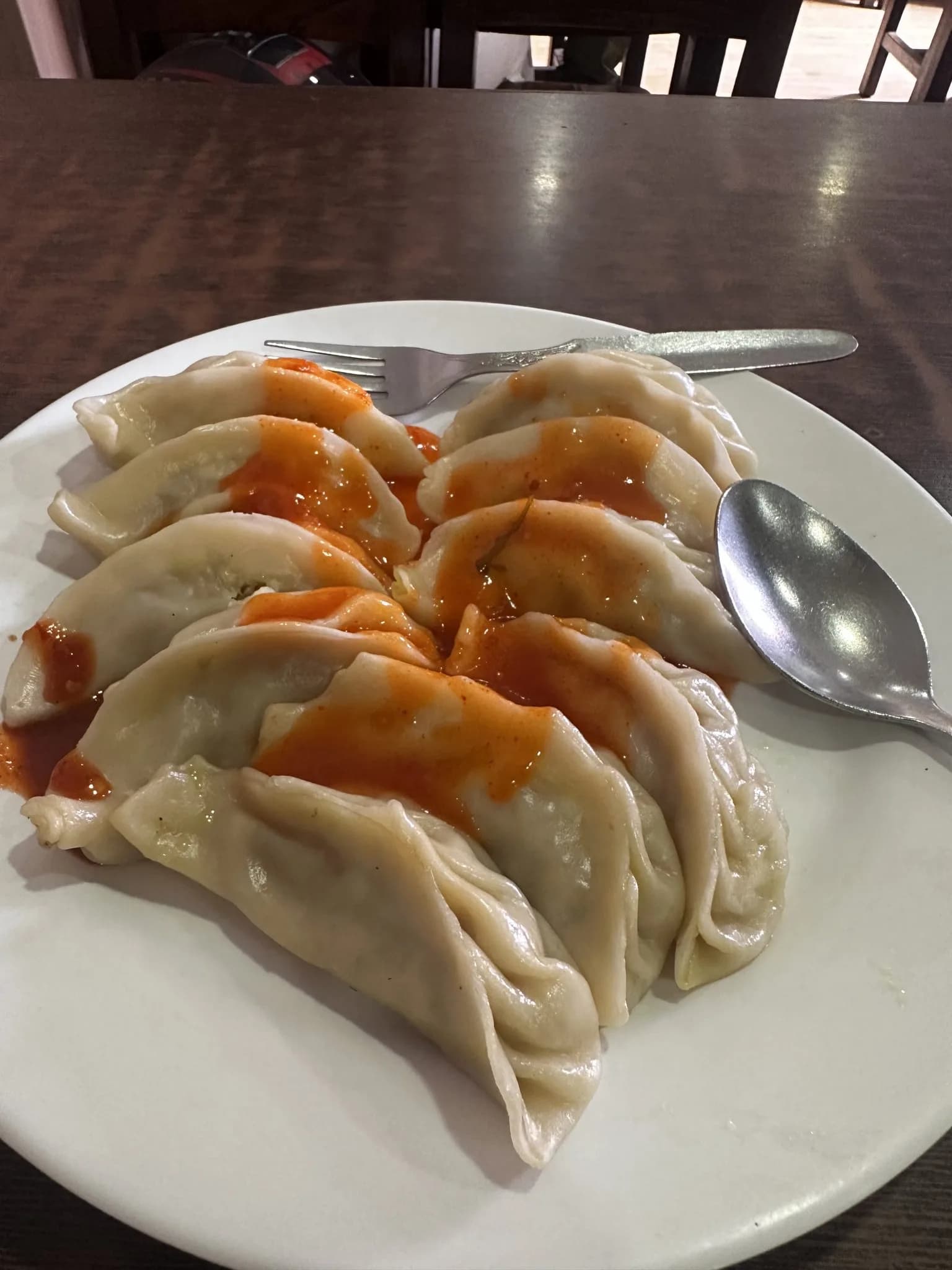 Momo topped with a light sauce on a plate